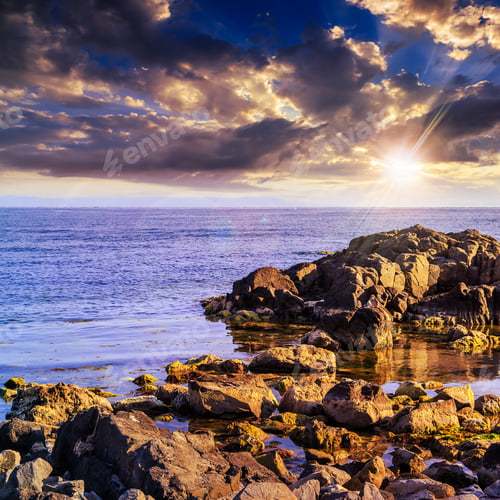 Preview: Sea Wave Attacks The Boulders And Is Broken About Them At Sunset