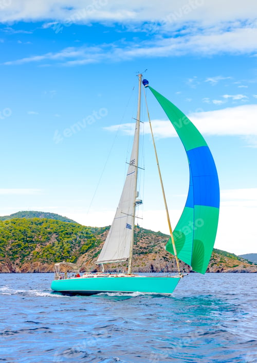 Preview: Sailing Boat With A Green - Blue Spinnaker During A Regatta Out Of Poros Island In Greece