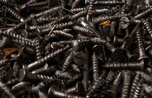 Preview: Techno Backgrounds - Black Oiled Bunch Of Screws On A Dark Grey Cardboard