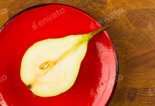 Preview: Half Ripe Pear In The Dish On A Wooden Background