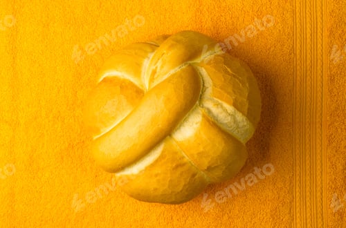 Preview: Fresh Braided Loaf Of White Wheat Bread On An Yellow Napkin