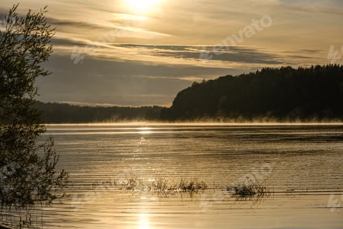 Vorschau: Bunte Herbstabendszene auf dem Land am Fluss mit alten Blättern im Wasser. Sonniger Tag