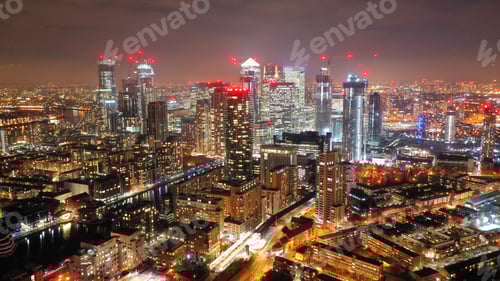 Visualização: Foto noturna aérea de drone a partir dos icônicos arranha-céus iluminados de Canary Wharf, comerciais e financeiros