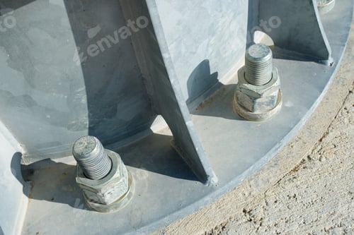 Preview: Close Up Of Some Larger Screws Into The Base Of A Metal Pillar.