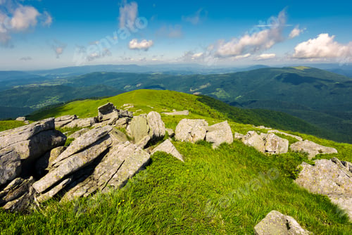 Preview: Boulders Down The Grassy Slope Of A Hill. Beautiful Sky Over The Distant Mountains. Stunning Summer