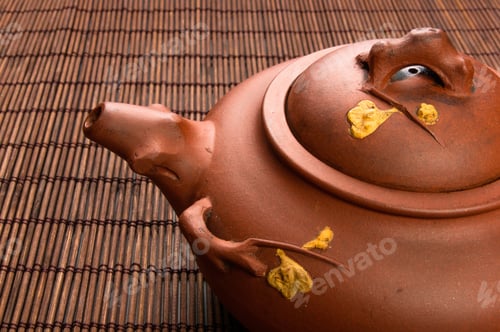 Preview: Brown Chinese Teapot Of Yixing Clay With Traditional Ornament On Bamboo Mat