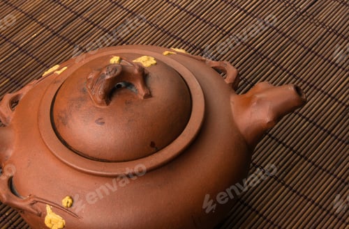 Preview: Brown Chinese Teapot Of Yixing Clay With Traditional Ornament On Bamboo Mat