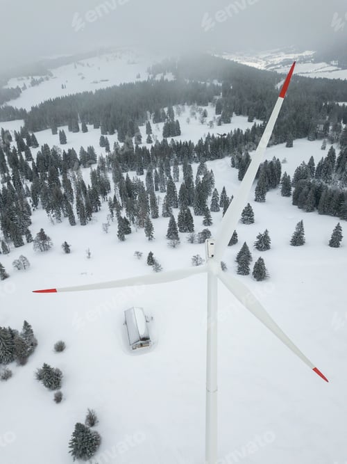 Preview: Aerial View Of Wind Turbine In Snow Covered Landscape In Switzerland. Tall Pylon In Fog, Fir Trees