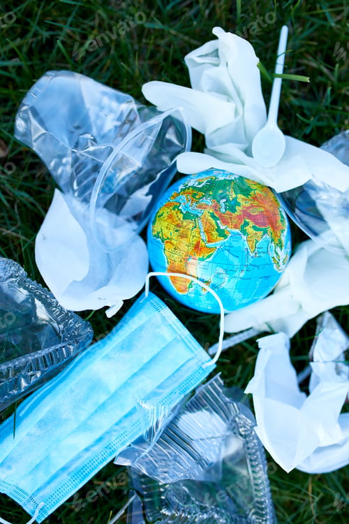 Preview: A Globe In A Pile Of Scattered Garbage On A Background Of Green Grass, Around Scattered Plastic