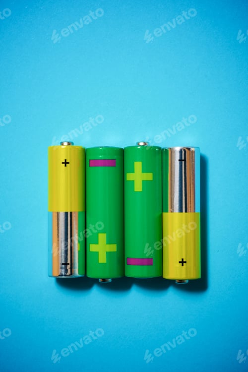 Preview: Small Batteries On A Blue Table.