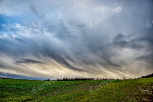 Vorschau: Wolken mit hohem Kontrast auf blauem Himmel über der Naturlandschaft im Sommer bei Sonnenuntergang