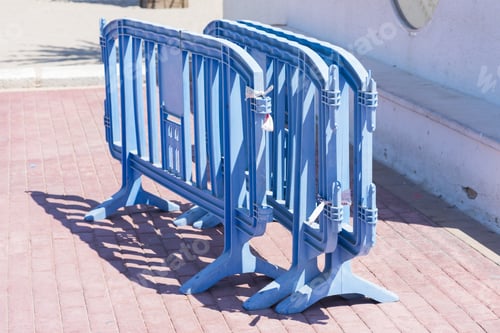Blue Temporary Barriers on Brick Sidewalk