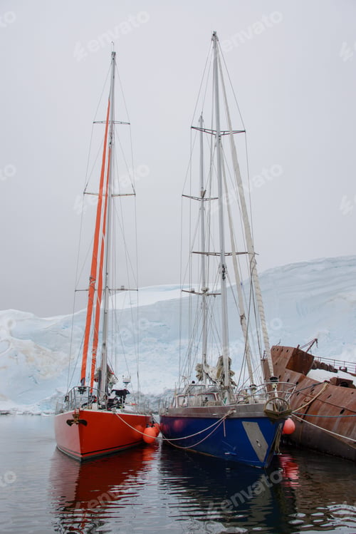 Preview: Two Sailing Yachts In The Antarctic Sea Moored To Rusty Wreck