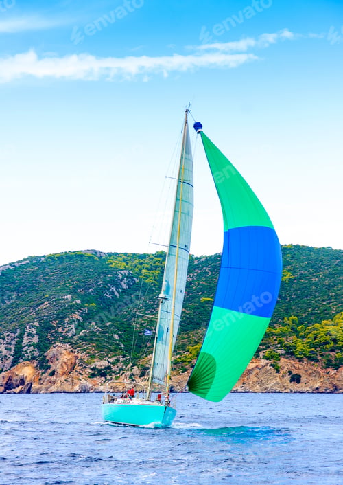 Preview: Sailing Boat With A Green - Blue Spinnaker During A Regatta Out Of Poros Island In Greece