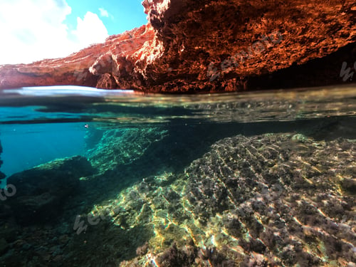 Preview: Underwater Above And Below Photo Of Rocky Seascape Arch Forming A Beautiful Emerald Lagoon In