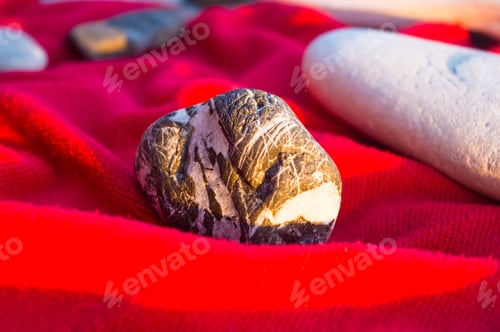 Preview: Red Towel And Stones On Pebble Beach, Sunset