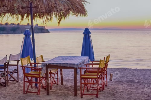 Preview: Sunset Photo Of Restaurant Table And Umbrella On The Beach In Greece