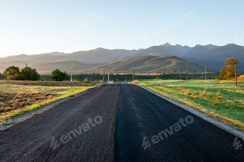 Preview: Winding Country Road With Clouds Above And Dry Tarmac