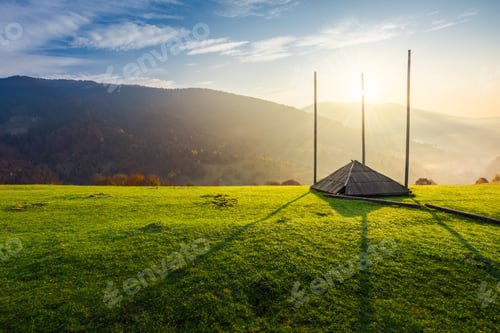 Preview: Empty Hay Barrack On A Grassy Hill At Sunrise. Beautiful Foggy Scenery In The Distant Valley. Rural