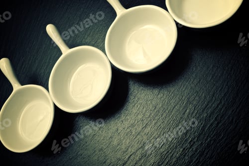 Preview: Four Small White Spoons On A Table Slate