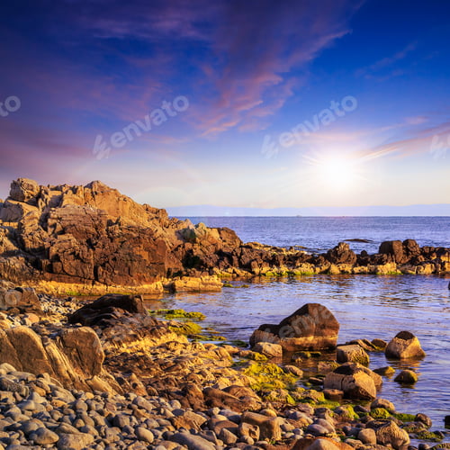 Preview: Sea Wave Attacks The Boulders And Is Broken About Them At Sunset