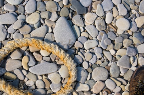Preview: Old Worn Battered Marine Rope On The Pebble Beach On A Sunny Summer Day, Top View