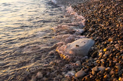 Preview: Sea Pebble Beach With Multicoloured Stones, Transparent Waves With Foam, On A Warm Evening