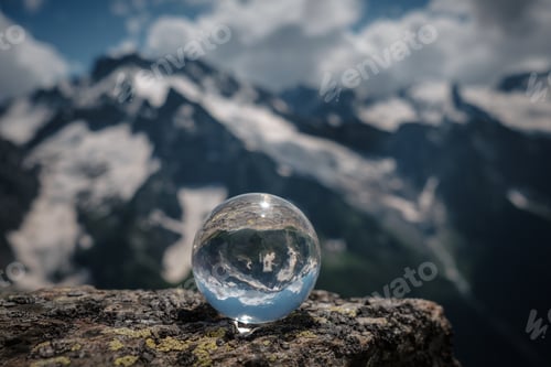 Preview: Transparent Glass Sphere And Snow-Capped Peaks In The Background. Concept And Idea Of Travel