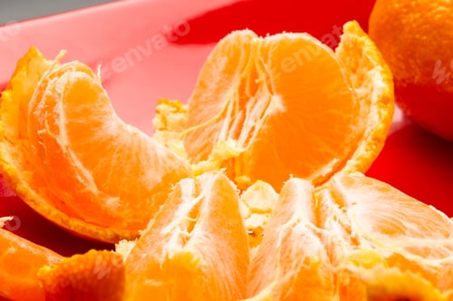 Preview: Tangerines, Peeled Tangerine And Tangerine Slices In A Red Plate On Black Background