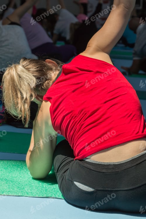 Preview: Blonde Girl With Red Sportswear Stretching Before Fitness Activity On Rubber Mat In Gym