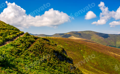 Preview: Summer Mountain Landscape. Path Through The Ridge To The Top Peak. Big Fluffy Clouds In A Blue Sky