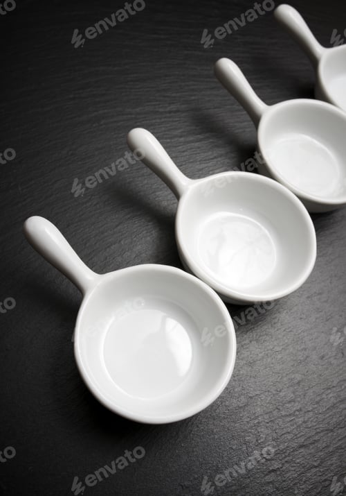 Preview: Four Small White Spoons On A Table Slate