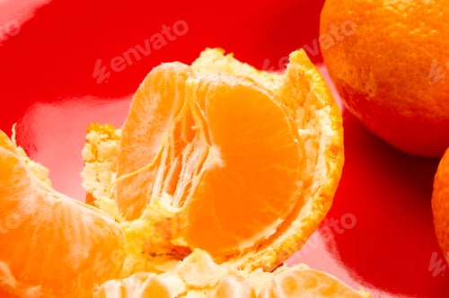Preview: Tangerines, Peeled Tangerine And Tangerine Slices In A Red Plate On Black Background