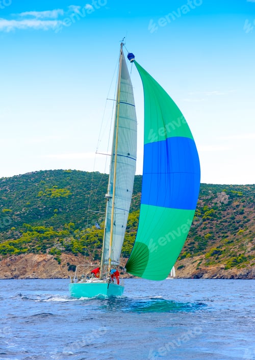 Preview: Sailing Boat With A Green - Blue Spinnaker During A Regatta Out Of Poros Island In Greece