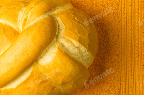 Preview: Fresh Braided Loaf Of White Wheat Bread On An Yellow Napkin