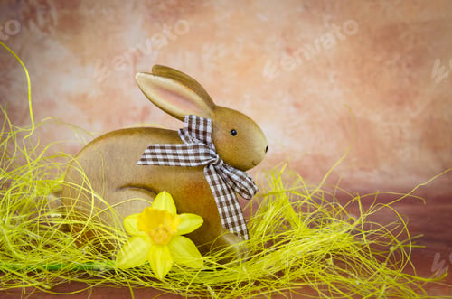 Preview: Brown Easter Bunny And Daffodil Decoration Against Dark Brown Background