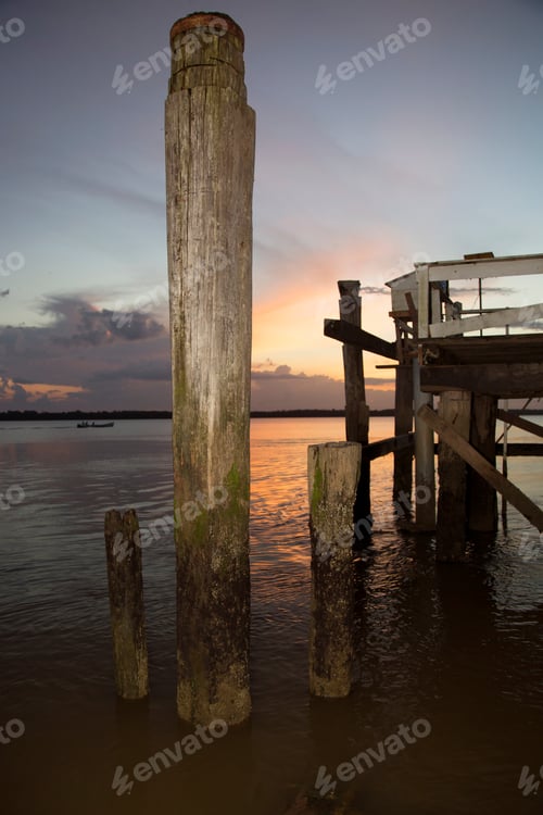 Preview: Silhouette At Sunset Of An Old Wooden Fishing Jetty And The Jungle Shoreline On The Other Side