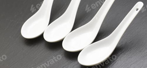 Preview: Four Small White Spoons On A Table Slate