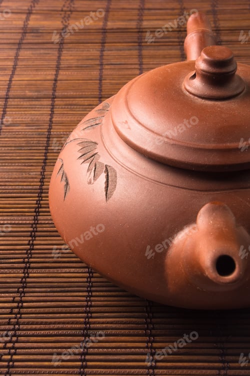 Preview: Brown Chinese Teapot Of Yixing Clay With Traditional Ornament On Bamboo Mat