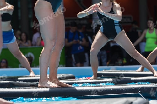Preview: Girl Doing Exercises On Floating Fitness Mat In An Outdoor Swimming Pool.