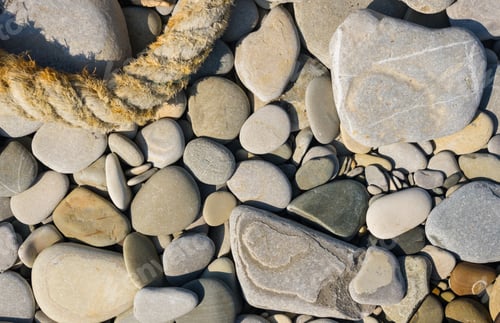 Preview: Old Worn Battered Marine Rope On The Pebble Beach On A Sunny Summer Day, Top View