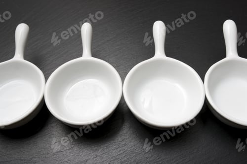 Preview: Four Small White Spoons On A Table Slate