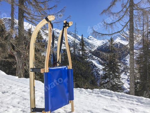 Preview: Wooden Sleigh Standing On Snow In Snow Covered Swiss Mountains. Forest In Background, Beautiful