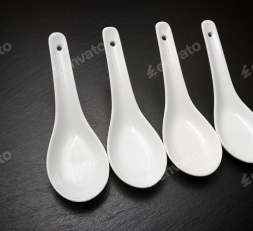 Preview: Four Small White Spoons On A Table Slate