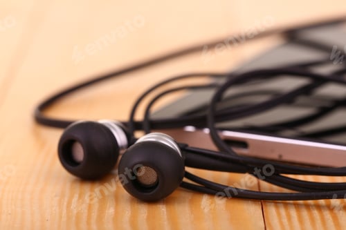 Preview: Mobile Phone With Pair Of Earphone On Wooden Table