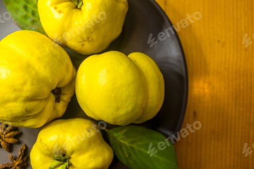 Preview: Large Yellow Quince Fruits On A Ceramic Plate, With Anise, Cinnamon, And Walnuts