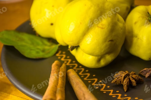 Preview: Large Yellow Quince Fruits On A Ceramic Plate, With Anise, Cinnamon, And Walnuts