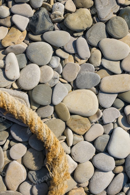 Preview: Old Worn Battered Marine Rope On The Pebble Beach On A Sunny Summer Day, Top View