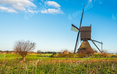 Preview: Dutch Polder Landscape With A Historic Wooden Hollow Post Mill As Seen From The Side. In The