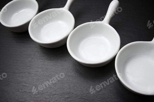 Preview: Four Small White Spoons On A Table Slate